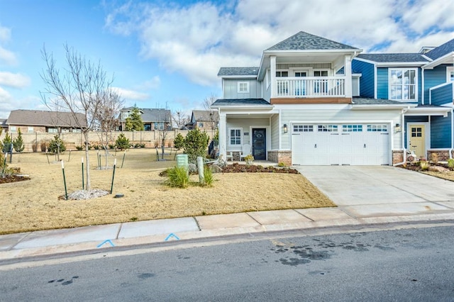 view of front of property with a balcony, a front yard, and a garage