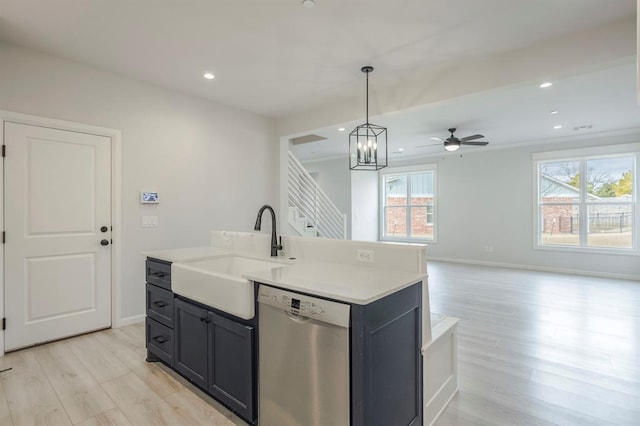 kitchen featuring ceiling fan with notable chandelier, dishwasher, decorative light fixtures, a kitchen island with sink, and light wood-type flooring