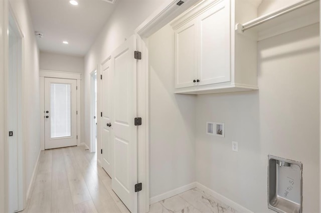 clothes washing area with cabinets and hookup for a washing machine