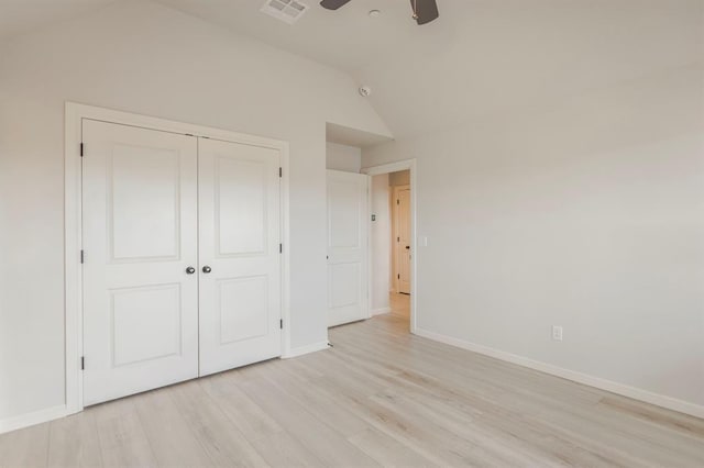 unfurnished bedroom with light wood-type flooring, a closet, lofted ceiling, and ceiling fan