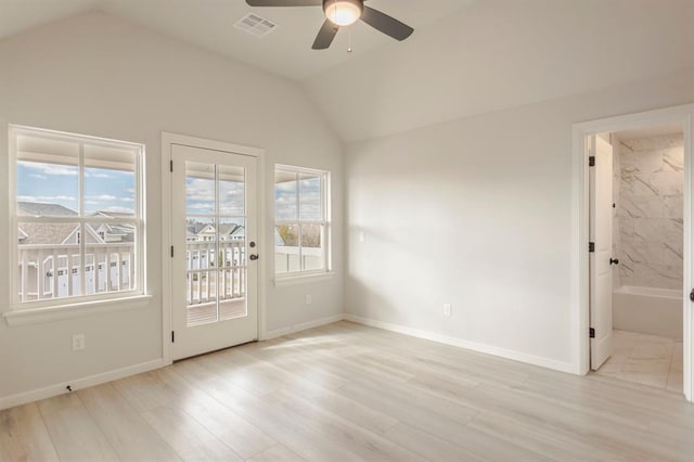 empty room with ceiling fan, vaulted ceiling, and light hardwood / wood-style floors