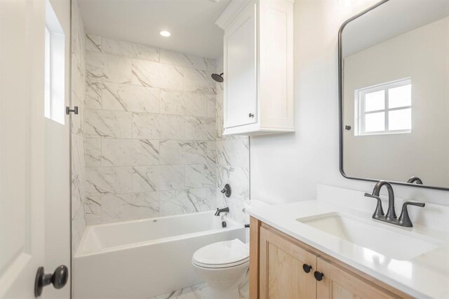 full bathroom featuring toilet, tiled shower / bath combo, and vanity