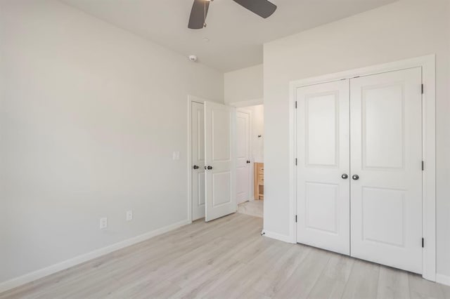 unfurnished bedroom featuring ceiling fan, a closet, and light hardwood / wood-style flooring