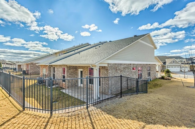 back of house featuring a patio area and a lawn