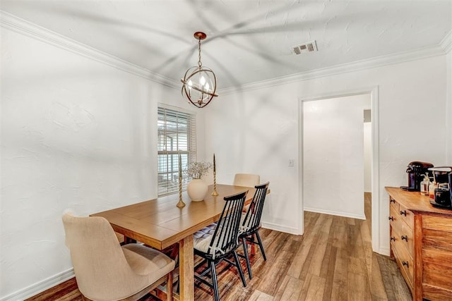 dining room featuring hardwood / wood-style flooring, crown molding, and an inviting chandelier