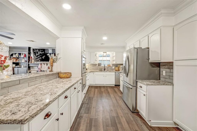 kitchen with white cabinetry, decorative backsplash, sink, and light stone countertops