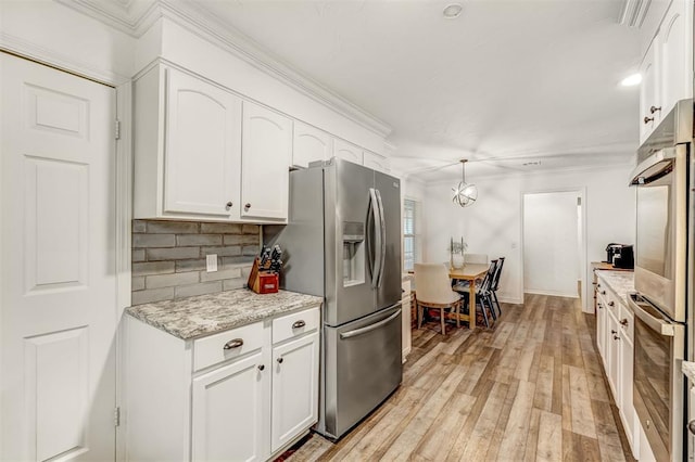 kitchen with white cabinets, pendant lighting, light stone counters, and stainless steel refrigerator with ice dispenser