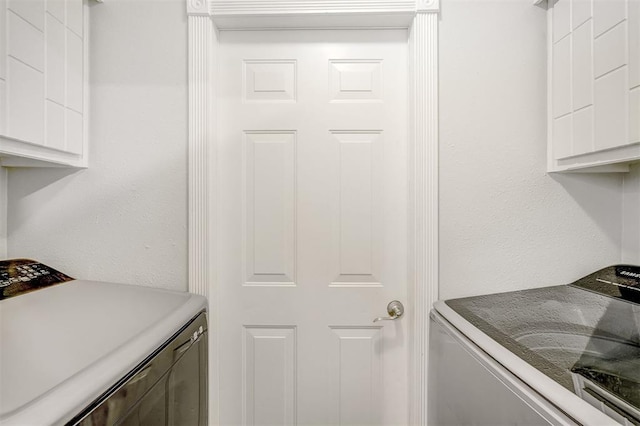 laundry area featuring washer and dryer and cabinets