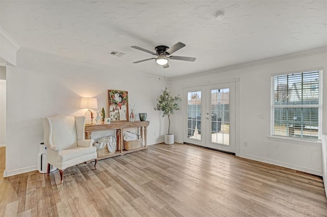 sitting room with ceiling fan, french doors, light hardwood / wood-style floors, and ornamental molding