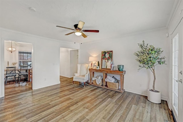 living area featuring crown molding, ceiling fan, and light wood-type flooring