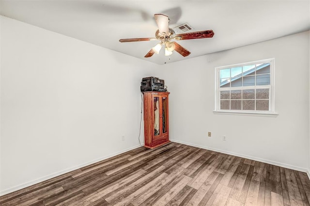 spare room featuring dark hardwood / wood-style floors and ceiling fan