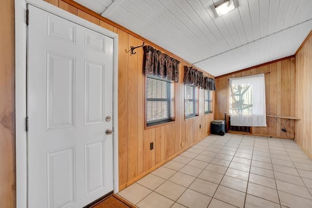 tiled spare room with wood walls and crown molding