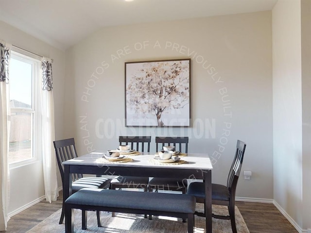 dining area with hardwood / wood-style floors, a wealth of natural light, and vaulted ceiling