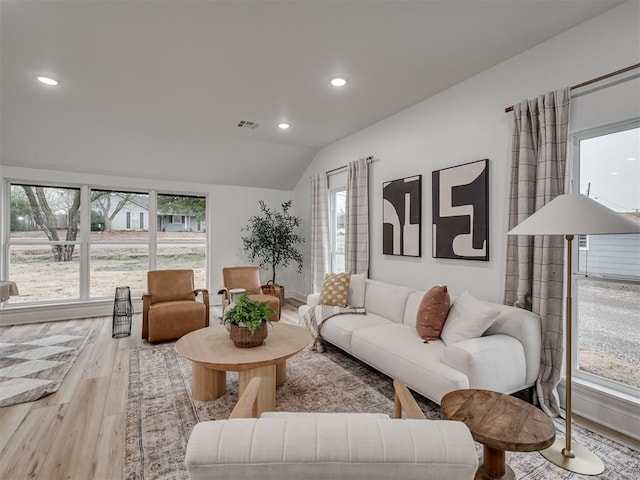 living room with light wood-type flooring and vaulted ceiling