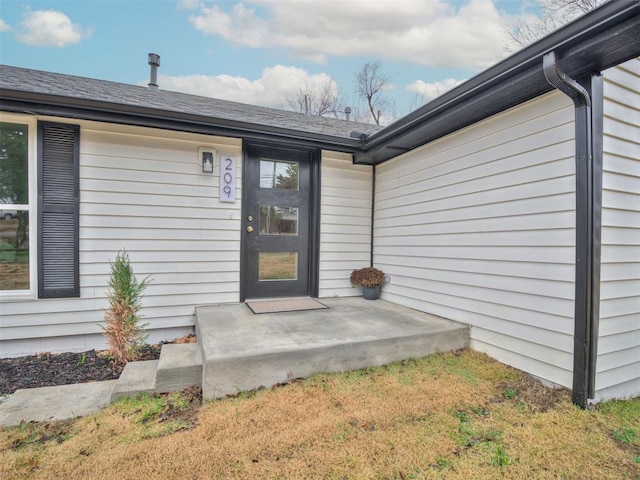 property entrance with a lawn