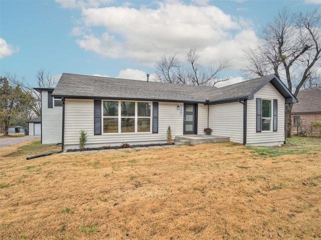 ranch-style home featuring a front yard and roof with shingles