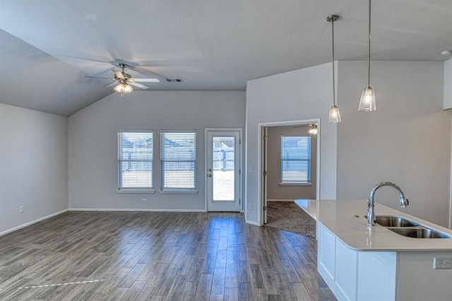 kitchen with lofted ceiling, sink, ceiling fan, hanging light fixtures, and white cabinets