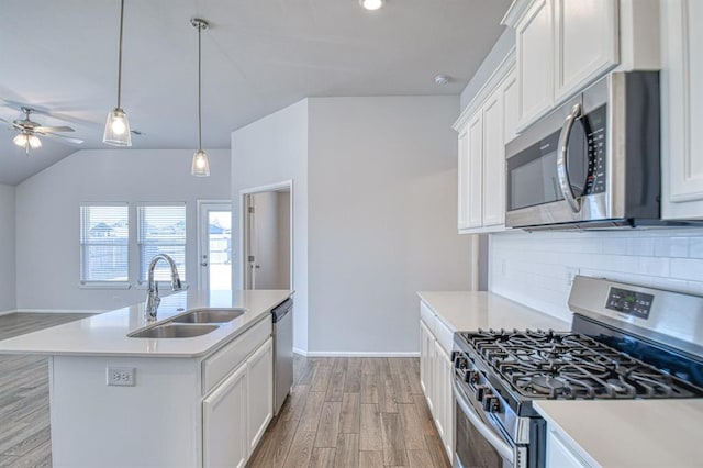 kitchen with stainless steel appliances, an island with sink, and white cabinets