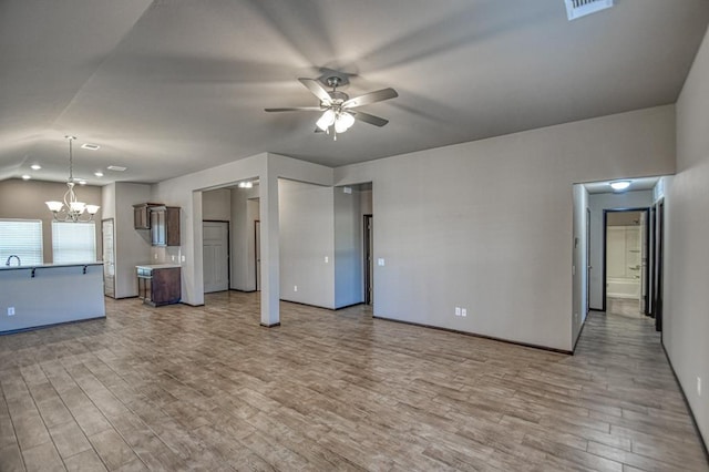 unfurnished living room with light wood-style floors, visible vents, and ceiling fan with notable chandelier