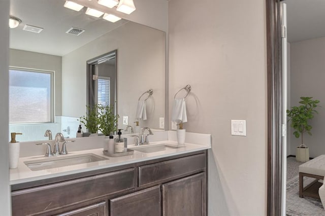 full bathroom with visible vents, a sink, and double vanity