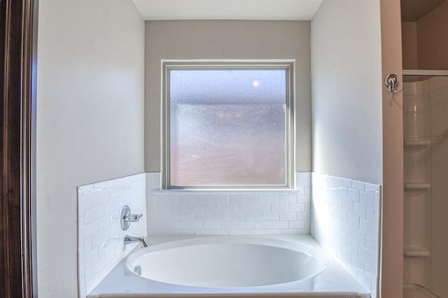 full bath featuring a garden tub and a shower