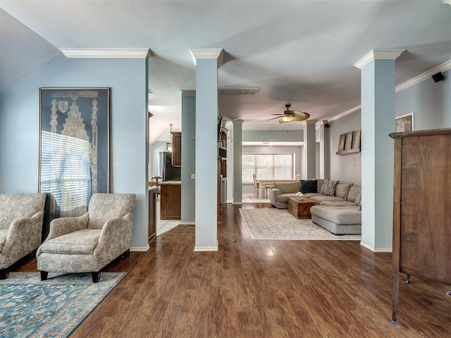 living room with crown molding, ceiling fan, wood-type flooring, and ornate columns