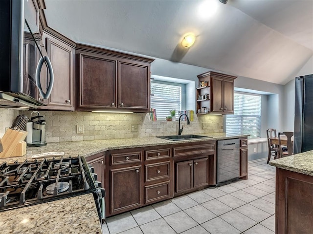 kitchen with appliances with stainless steel finishes, lofted ceiling, sink, decorative backsplash, and dark brown cabinetry