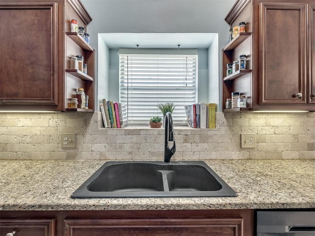 kitchen featuring sink, backsplash, and light stone countertops