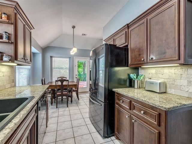 kitchen with lofted ceiling, backsplash, hanging light fixtures, light stone countertops, and light tile patterned flooring