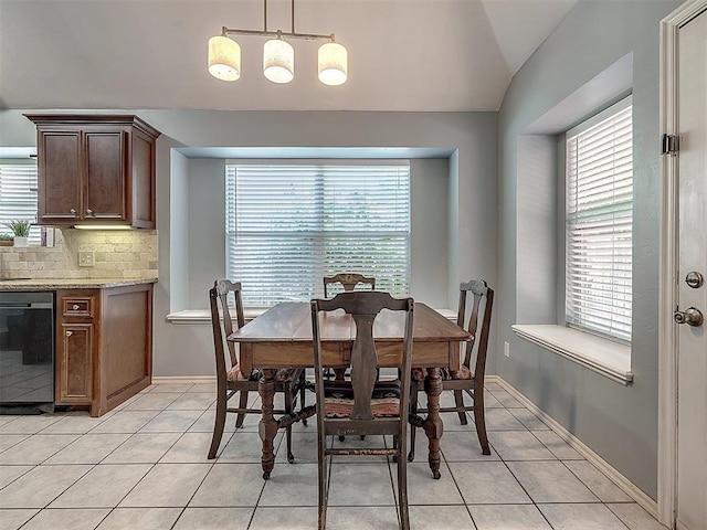 tiled dining room with lofted ceiling and a healthy amount of sunlight