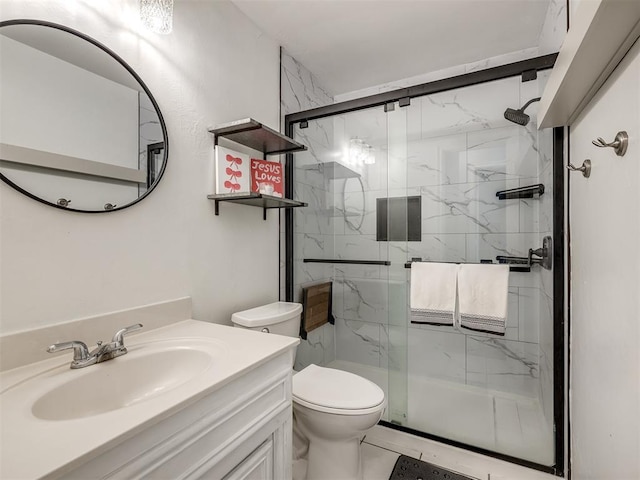 bathroom with tile patterned flooring, vanity, a shower with shower door, and toilet