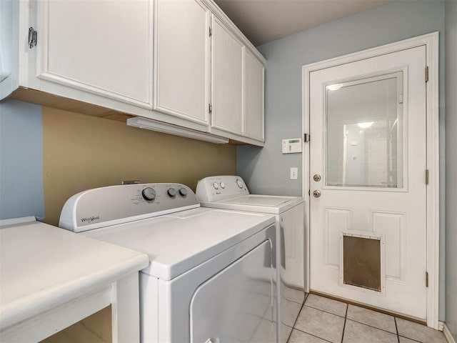 laundry area with cabinets, independent washer and dryer, and light tile patterned flooring