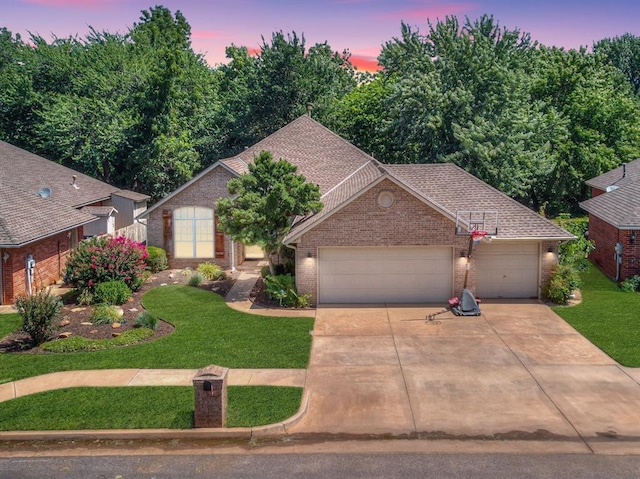 view of front of home with a garage and a lawn