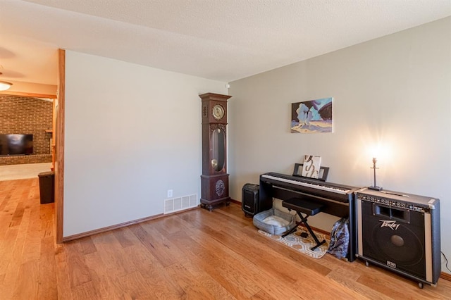 misc room with a fireplace and light hardwood / wood-style floors