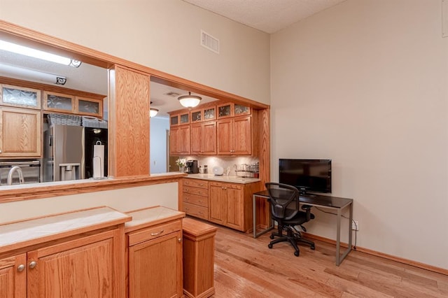 kitchen with stainless steel fridge and light wood-type flooring