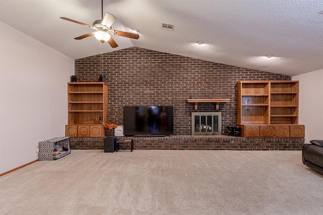 unfurnished living room with ceiling fan, lofted ceiling, a textured ceiling, a fireplace, and carpet