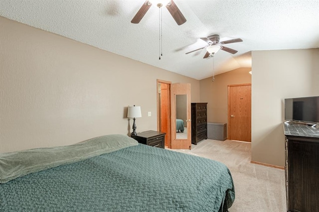 carpeted bedroom with a textured ceiling, ceiling fan, and vaulted ceiling