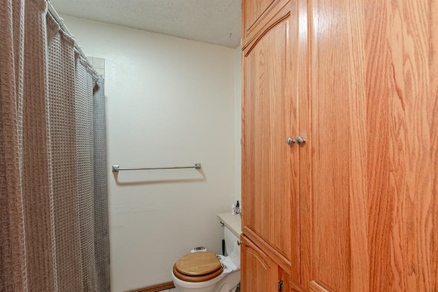 bathroom featuring a textured ceiling and toilet