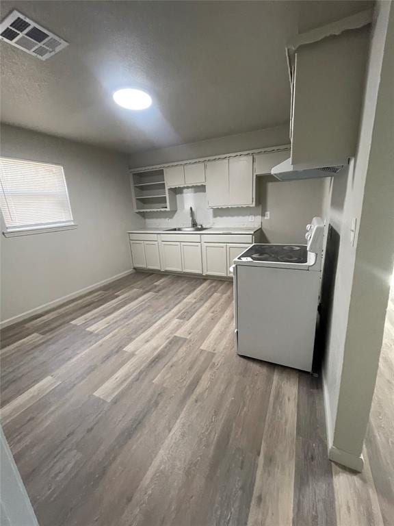 kitchen featuring range, light hardwood / wood-style floors, white cabinetry, and sink