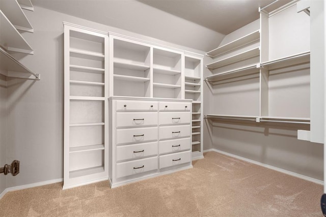 spacious closet with vaulted ceiling and light colored carpet