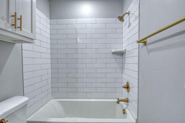 bathroom featuring tiled shower / bath combo and toilet