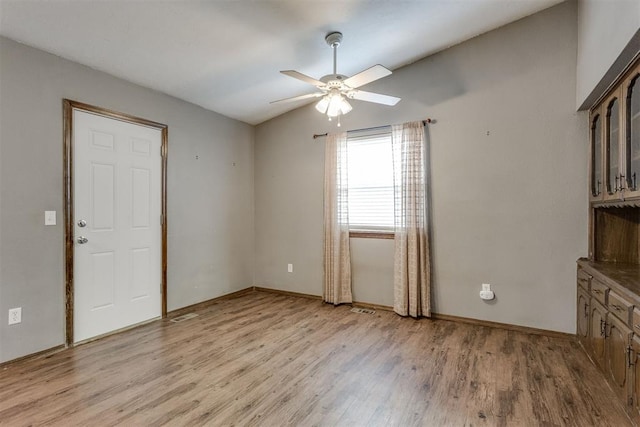 empty room featuring ceiling fan, light hardwood / wood-style floors, and lofted ceiling