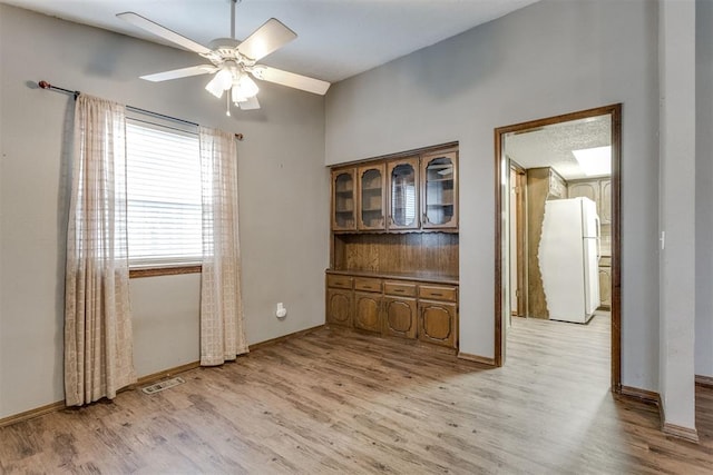 unfurnished dining area with ceiling fan and light hardwood / wood-style floors