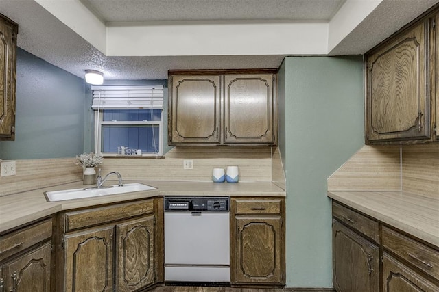 kitchen featuring white dishwasher, tasteful backsplash, sink, and a textured ceiling