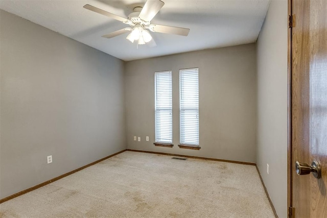 empty room featuring ceiling fan and light colored carpet