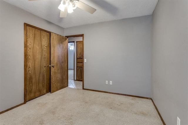 unfurnished bedroom with a closet, ceiling fan, and light colored carpet