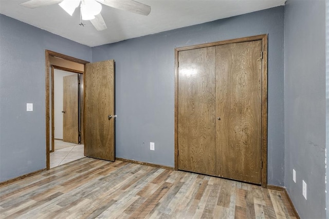 unfurnished bedroom with a closet, light hardwood / wood-style floors, and ceiling fan