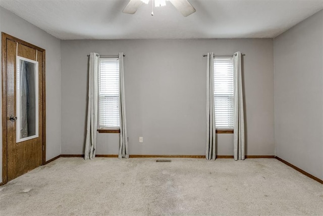 carpeted spare room with ceiling fan