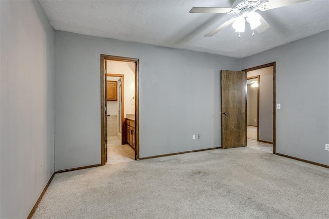 unfurnished bedroom with connected bathroom, ceiling fan, light carpet, and a textured ceiling