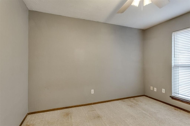 carpeted empty room with ceiling fan and a wealth of natural light